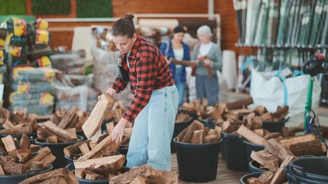 Girl chooses and buys a bundle of firewood at a hardware store. . High quality 4k footage