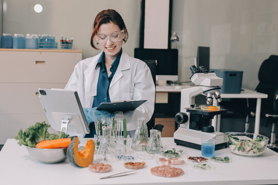Scientists in lab coats work with plants in a modern lab, focusing on research and experimentation under bright, sterile conditions.
