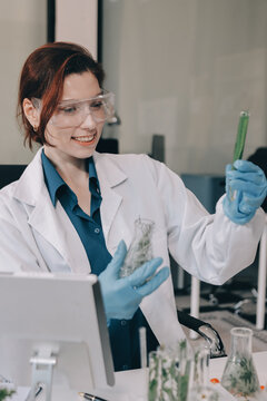 Scientists in lab coats work with plants in a modern lab, focusing on research and experimentation under bright, sterile conditions.