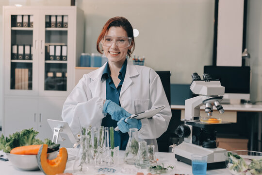 Scientists in lab coats work with plants in a modern lab, focusing on research and experimentation under bright, sterile conditions.