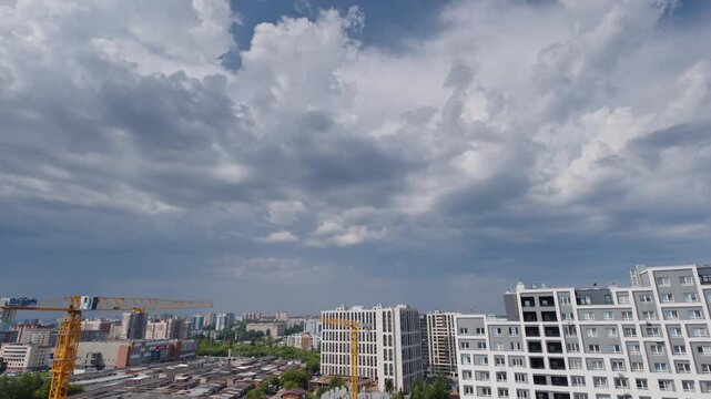 Timelapse of the clouds running fast over the buildings in a city