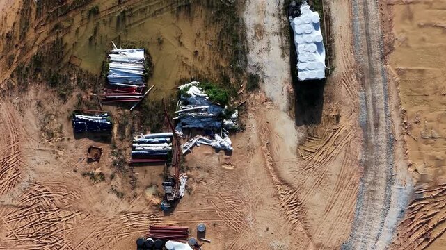 Aerial view shows construction site with circular tracks from machinery