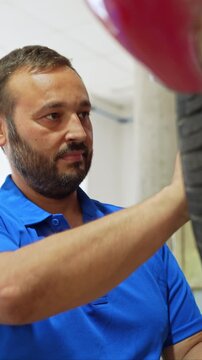 Professional auto mechanic performing wheel alignment service