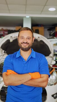 Confident auto mechanic posing in repair shop