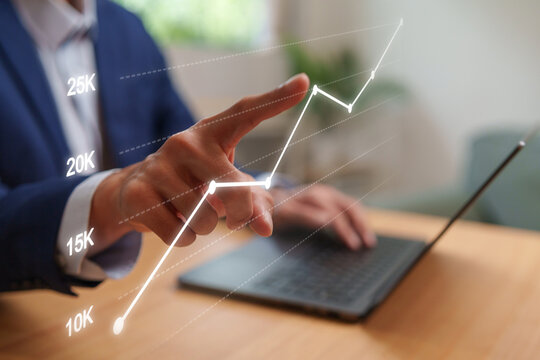 Businessman analyzing a digital growth chart on laptop, presenting business analytics, financial performance, and strategic planning.