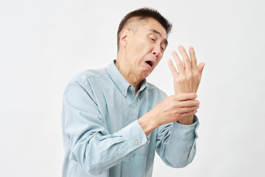 白背景で手首が痛い男性
