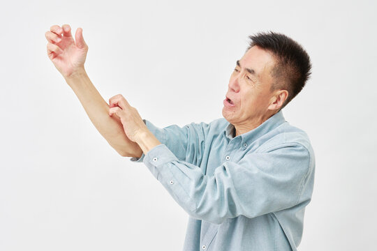 白背景で腕を掻く男性