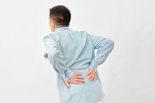 白背景で腰を押さえる男性