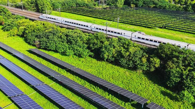 Drone tracking a high speed train beside solar panels