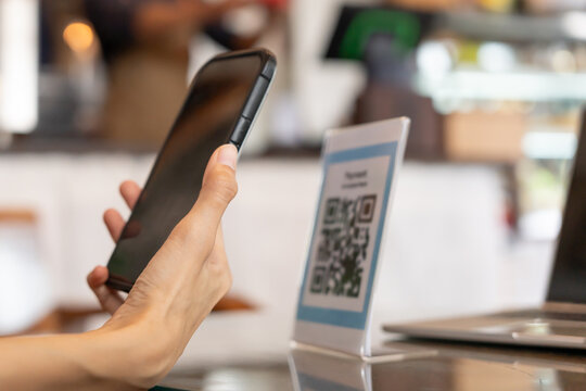 Woman use smartphone to scan QR code to pay in cafe restaurant with a digital payment without cash. Choose menu and order accumulate discount. E wallet, technology, pay online, credit card, bank app.