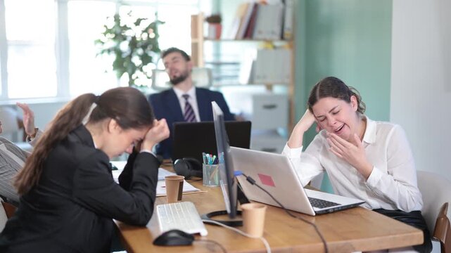Exhausted office colleagues sleeping at desks after long stressful workday in corporate workspace