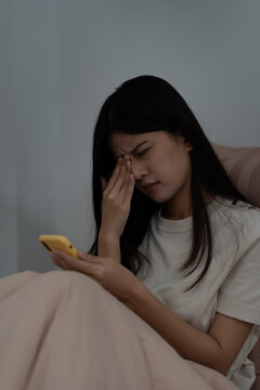 Eye problems, Asian women use hand cover eyes due to eye irritation, eye rubbing, dry, eye pain after look mobile phone long time in low light, migraine, headache, blurred vision, photophobia