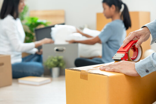 Moving house, relocation. Husband use tape pack box for movement, couple on new home. inside the room was a cardboard box containing personal belongings and furniture. move in condominium