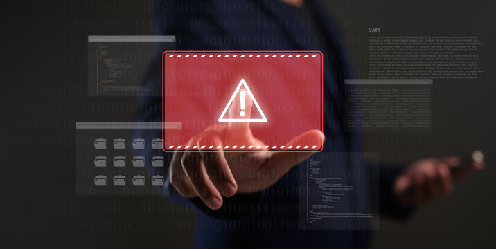 A person interacts with a virtual interface displaying a digital warning symbol and code, highlighting cybersecurity and data protection concerns.