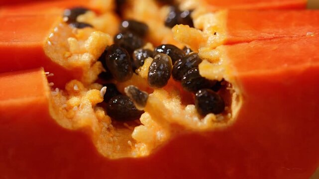 Close-up of ripe papaya flesh and glossy black seeds, showcasing the vibrant orange color and natural texture of this tropical fruit. Rich in vitamins, antioxidants, and dietary fiber, the image is id