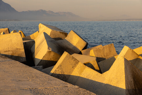 distinctive concrete cubist breakwater design, new Harbor, Hermanus, South Africa at sunset and dusk