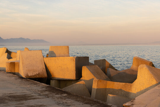 distinctive concrete cubist breakwater design, new Harbor, Hermanus, South Africa at sunset and dusk