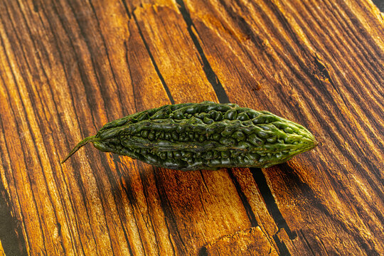 Green bitter melon on rustic wooden surface