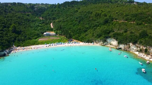Aerial flyover toward the Greek island paradise of Antipaxos, a jewel of the Ionian Islands, where turquoise waters and Mediterranean beauty define the perfect summer destination