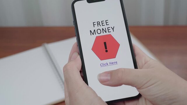 Hand holds a smartphone with an AI information interface flagging a fake Free Money click here offer as a potential scam.