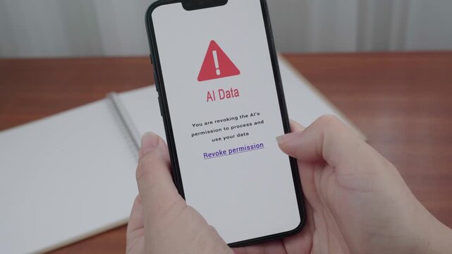 User holds a smartphone as an AI Data message prompts them to revoke permission to process and use their data.