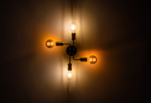 Dimmed Ceiling Lamp with Light Bulb Symbolizing Rising Energy Costs, Power Supply, Blackouts and CO₂ Emission Allowances.