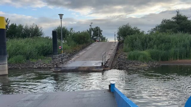 Vehicle Ferry Leaving Riverside Ramp on the Elbe River in Germany