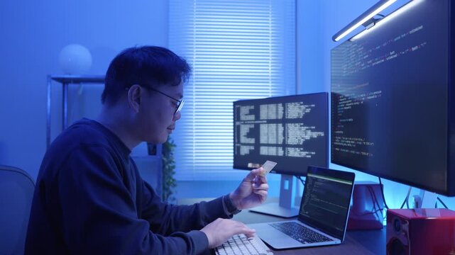 Asia man Programmer Holding Credit Card to Purchase Software Subscription Online.