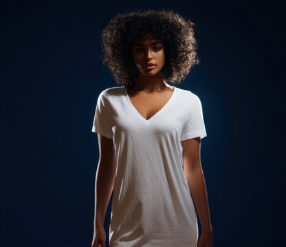 Young woman in white t-shirt and shorts posing against blue studio background, perfect for fashion catalog or e-commerce mockup.