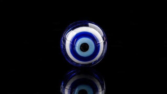 Traditional blue glass evil eye talisman isolated on black background for spiritual protection and good luck concept with talisman protection spiritual