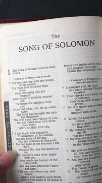 Kuala Lumpur, Malaysia - July 22nd, 2026: Opening to the Song of Solomon book of the Old Testament in the Holy Bible. New Revised Standard Version. Vertical video.