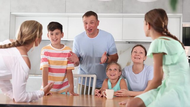  Big tight-knit friendly family getting together and talking at kitchen at their free time