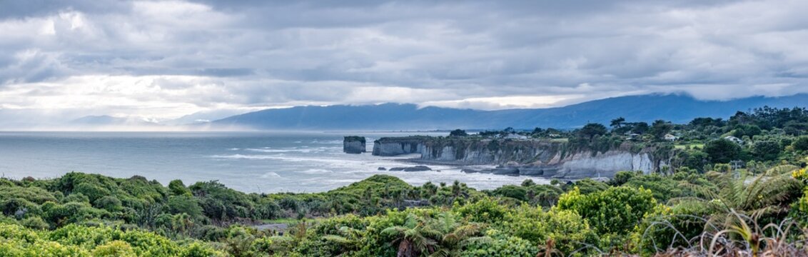Dramatische Kuestenlandschaft am Cape Foulwind Neuseeland mit Felsformationen und stimmungsvollem Wolkenhimmel