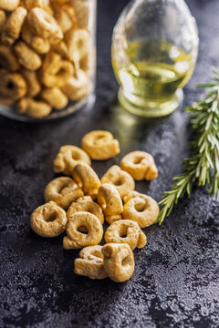 Italian Taralli Crackers With Olive Oil and Rosemary in a Glass Jar on Dark Surface