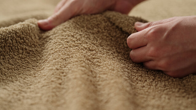 closeup shot of man touching green cotton terry towel