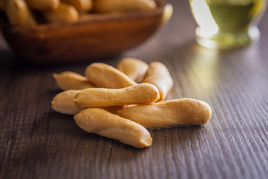 Crispy Breadsticks on Wooden Table With Bowl and Olive Oil for Snack or Appetizer