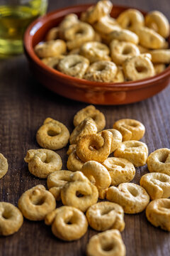 Crispy Taralli Italian Snack Rings on Rustic Wooden Table with Bowl and Olive Oil