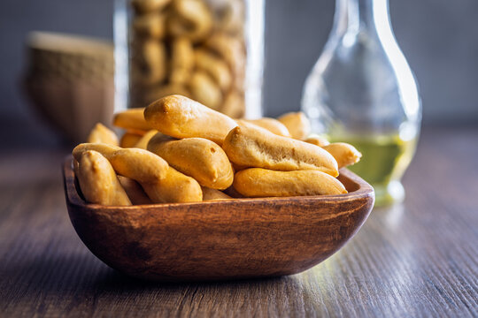 Golden Breadsticks in Wooden Bowl on Rustic Table with Olive Oil Bottle and Appetizer Snack
