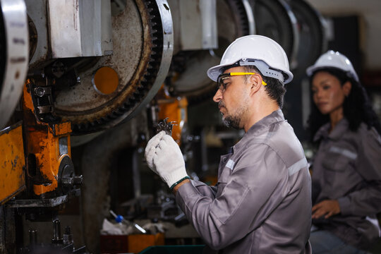 Industrial Technician Inspecting Precision Metal Component During Manufacturing Quality Control