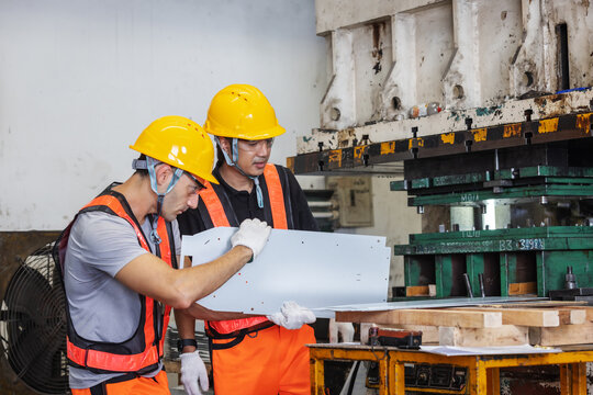 Industrial Engineers Inspecting Metal Panel Before Production on Heavy Press Machine