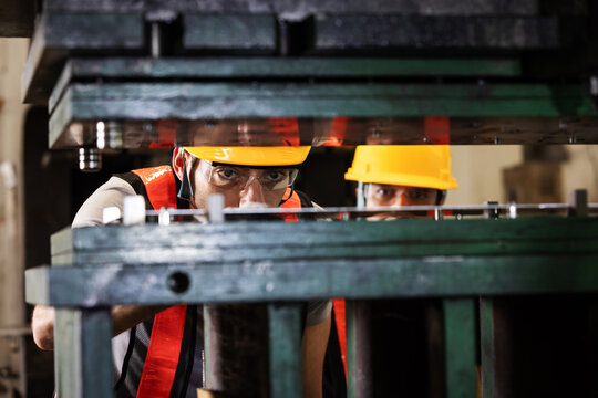 Industrial Engineers Inspecting Sheet Metal Alignment Before Stamping Process on Press Machine