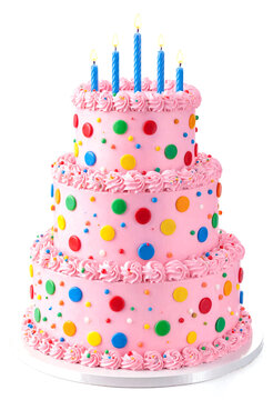 Colorful threetier birthday cake with pink frosting and polka dots topped with lit candles