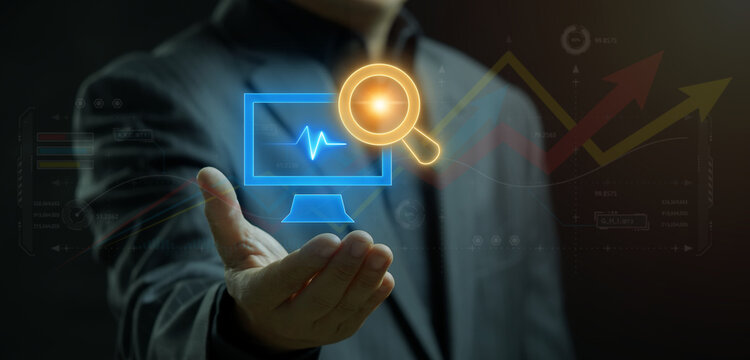Businessman holding glowing monitor display showing computer screen with financial growth graph line under magnifying glass. Digital financial report audit and computer analytics inspection concept.