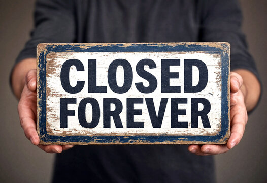 Person holding a vintage wooden sign with closed forever message in bold letters