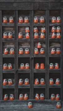 Daruma Dolls Displayed on Wooden Temple Shelves