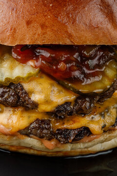 Juicy cheeseburger isolated on a black background.