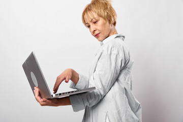 Woman with laptop, isolated on white background, focused profile portrait, remote work and communication concept, modern technology, soft studio light, clean © SHOTPRIME STUDIO