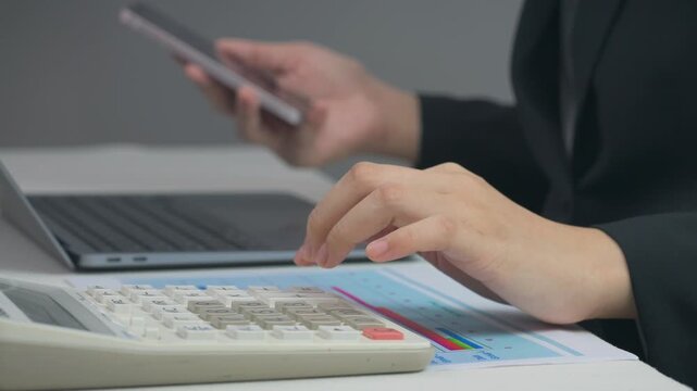 Professional accountant hand types on laptop near calculator and finance document planning budget to reach home ownership goal at office desk
