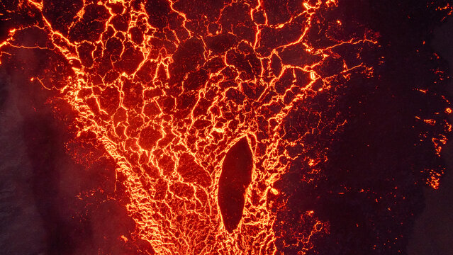Aerial view of the Litli-Hrutur volcanic eruption with glowing magma flowing through cracked earth in Grindavik, Grindavikurbaer, Iceland.