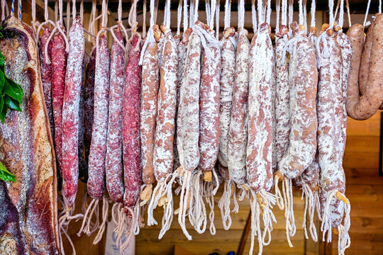 Assortment of artisanal hanging cured sausages including chorizo and fuet at a Catalan market